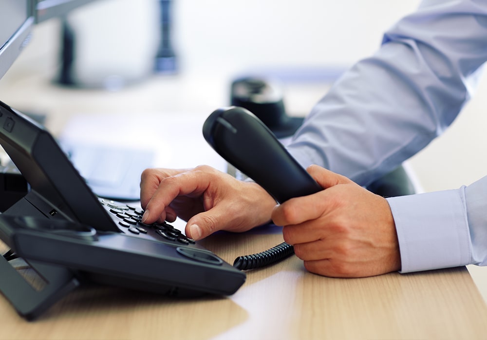 Man's hand picking up the phone. Rich makes a lot of phone calls while developing your eligibility.